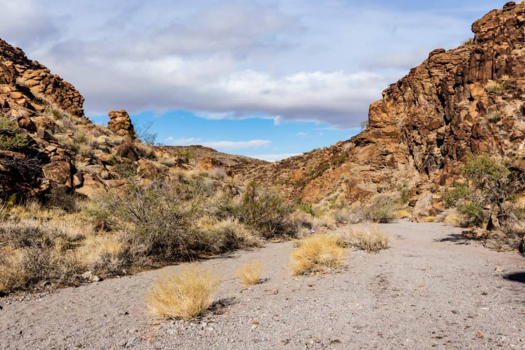 A small dirt area with rock formations surrounding it. 