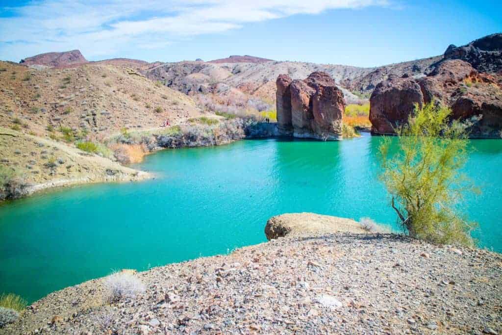 Bright blue water in the valley of a hilly, desert area. 